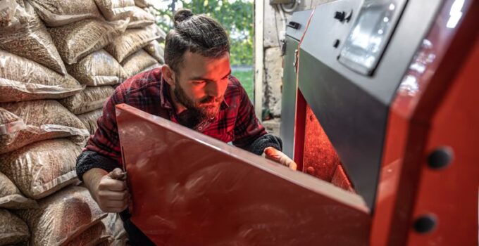 Un jeune homme qui regarde dans une chaudière à granulés